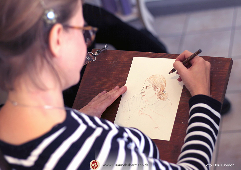 Porträtzeichnen - der Künstlerin beim Zeichnen über die Schulter geschaut