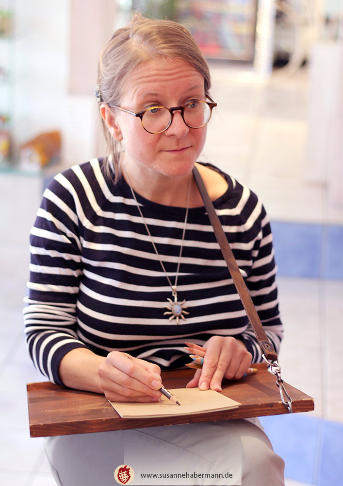 Porträtzeichnen - Künstlerin beim Zeichnen auf einem Zeichenbrett - Porträtzeichnen auf Veranstaltungen mit Susanne Habermann