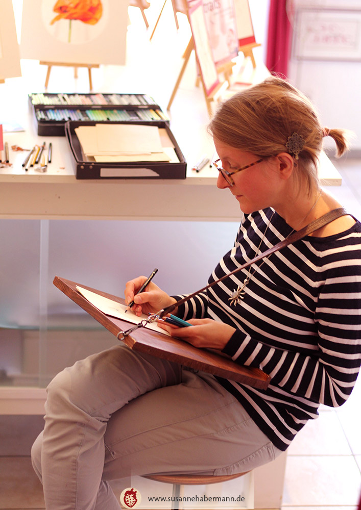 Porträtzeichnen - Künstlerin beim Zeichnen auf einem Zeichenbrett